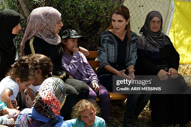 Queen Rania of Jordan speaks with migrants and refugees during her visit at the refugee site of Kara Tepe in Mytilene on April 25, 2016. / AFP / ARIS...