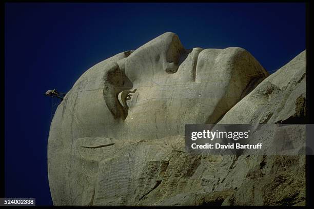 Workers scale the faces of Mount Rushmore while doing annual maintenance work on the four US presidents. George Washington is visible here. The...