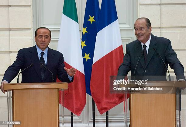 Italian Prime Minister Silvio Berlusconi gestures while making a point and French President Jacques Chirac cracks a smile during the joint press...