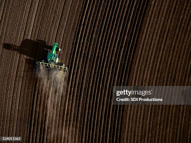 high angle view of tractor plowing a field - ploughing stock pictures, royalty-free photos & images