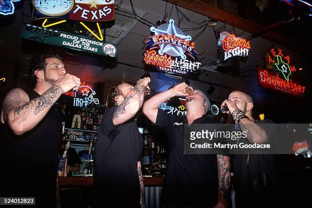 Drowning Pool drink shots in a bar in Dallas, Texas, United States, 2002. The line up contains Dave Williams, CJ Pierce, Steve Benton and Mike Luce.