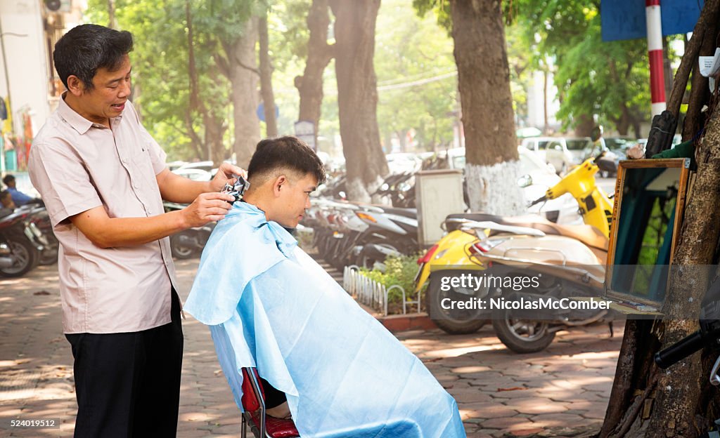 Vietnamese haircutter entraining customer