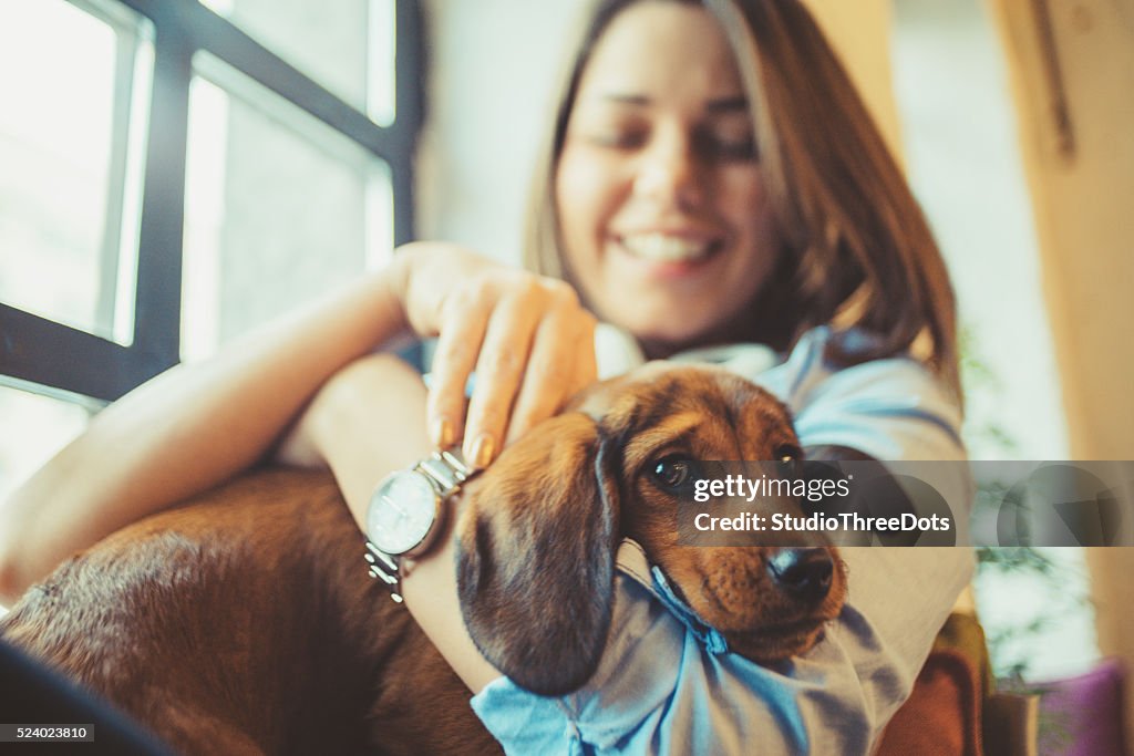 Attractive young woman playing with puppy