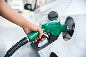 Handle fuel nozzle to refuel the car.