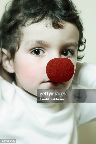 portrait of child with a red clown nose - clownsneus stockfoto's en -beelden