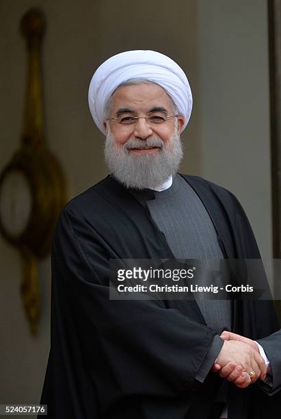 French President Francois Hollande welcomes Iranian President Hassan Rohani before their talks at the Elysee Palace in Paris, France on January 28,...