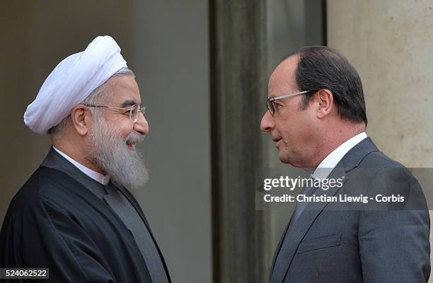 French President Francois Hollande welcomes Iranian President Hassan Rohani before their talks at the Elysee Palace in Paris, France on January 28,...