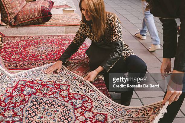 woman buying carpets - perzisch tapijt stockfoto's en -beelden