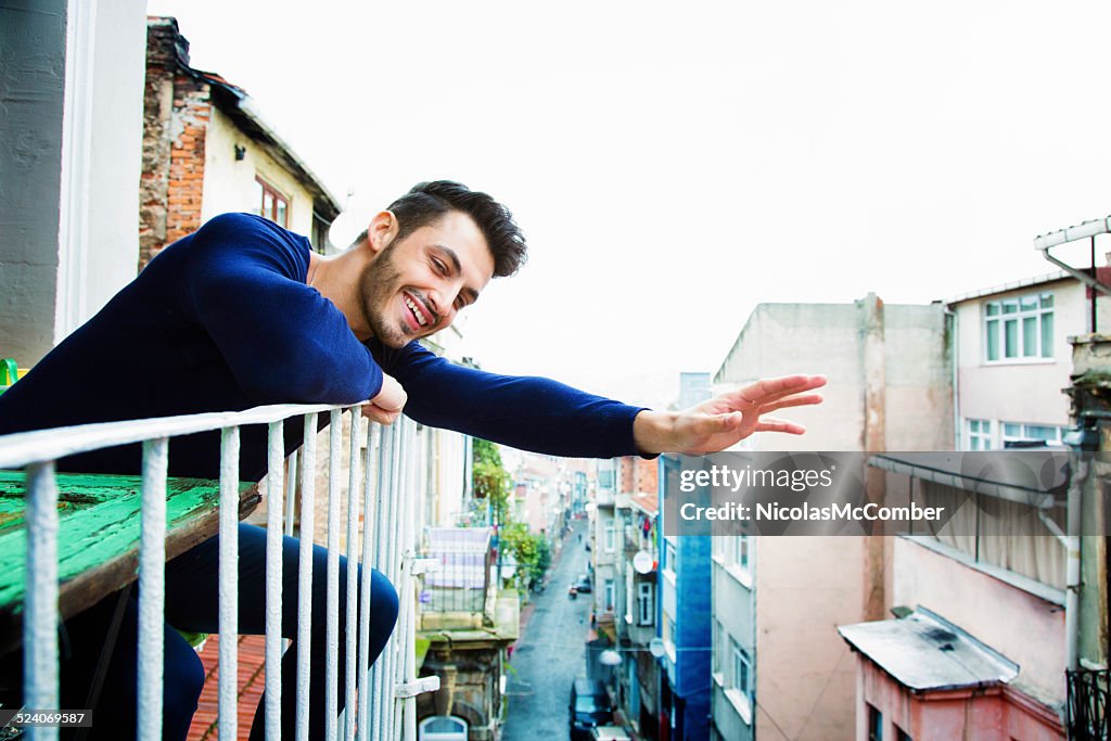 Bel homme turc vagues Bonjour depuis son balcon