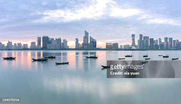 fishing boats floating on qiantang river against qianjiang new town cbd, hangzhou,china - hangzhou bildbanksfoton och bilder