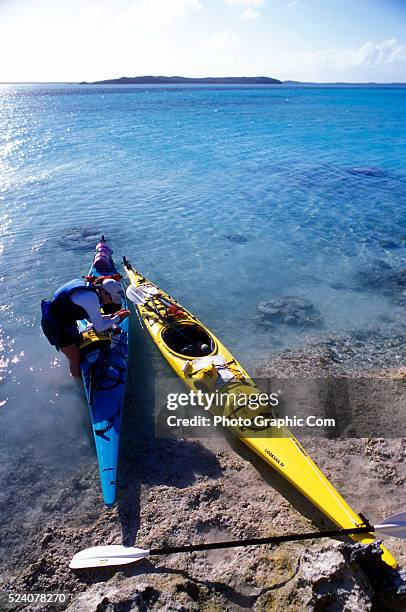 Participant on an Outward Bound adult expedition ages 26 and over, prepares to leave shore on an 8 day sea kayaking course in the Exuma Islands of...