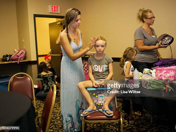 Contestant getting her hair and makeup done before she goes on stage during the Miss Cutie beauty pageant at the Crowne Plaza in Syracuse, New York...
