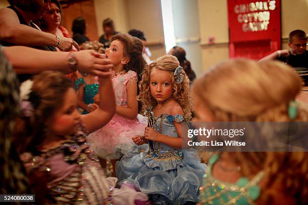 Young contestants eating pixie stix to boost their energy before performing their beauty walks during the Under the Big Top Pageant at the Holiday...