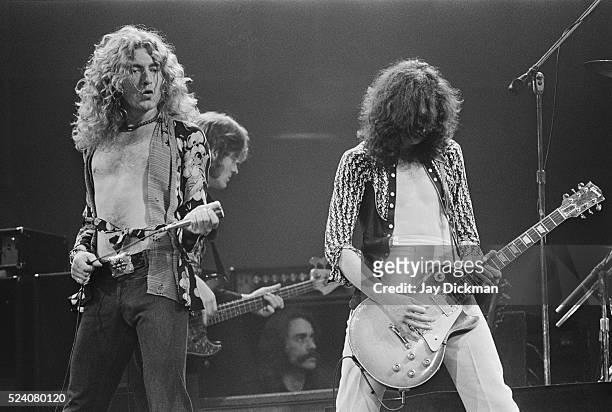 Singer Robert Plant and lead guitarist Jimmy Page of Led Zeppelin perform in concert. Bassist John Paul Jones is behind Plant.