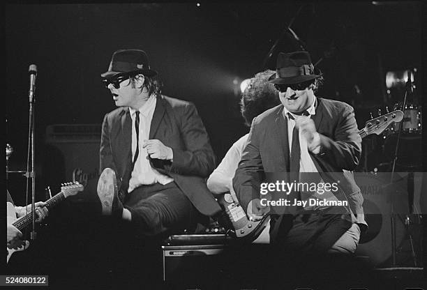 Dan Aykroyd and John Belushi performing on stage as the Blues Brothers.