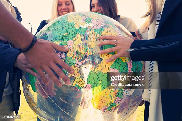 grupo de jovens segurando um globo do mundo - students map imagens e fotografias de stock