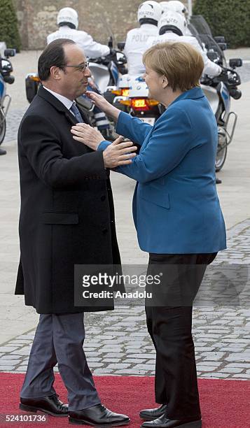 German Chancellor Angela Merkel welcomes French President Francois Hollande before their meeting at Schloss Herrenhausen palace in Hanover, Germany...