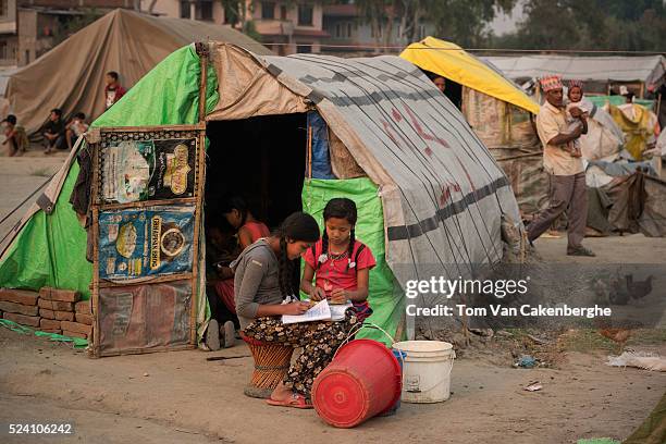 Young girls doing their homework after school outside their tent at Chuchepati displacement camp, a sprawling squalid displaced shelter for...