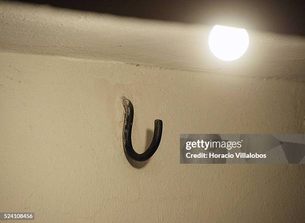 Hook projects its shadow on the wall at the 'Strangling Room', called by the Nazis ‘Leichenkeller' , at the basement of the crematorium in Buchenwald...