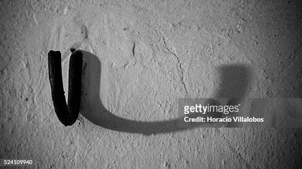 Hook projects its shadow on the wall at the 'Strangling Room', called by the Nazis ‘Leichenkeller' , at the basement of the crematorium in Buchenwald...
