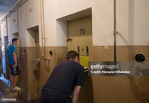 Visitors peer into the cells at the 'Bunker', or cell block, in Buchenwald concentration camp near Weimar, Germany, 21 July 2013. The camp,...
