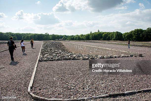 Visitors walk by the memorial created, where Block 22 barracks once stood, with stones brought from the camp's quarry to pay homage to the Jews who...