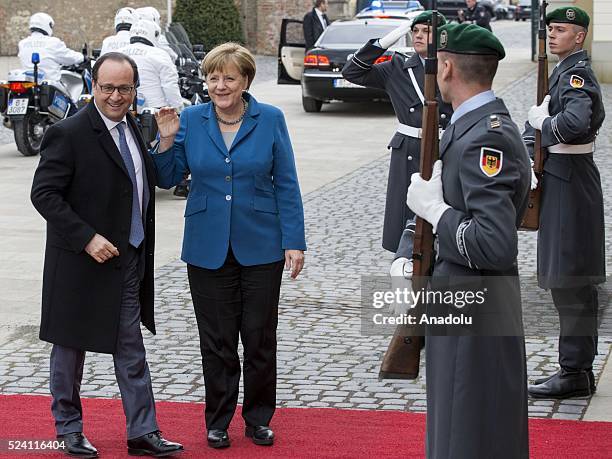 German Chancellor Angela Merkel welcomes French President Francois Hollande before their meeting at Schloss Herrenhausen palace in Hanover, Germany...