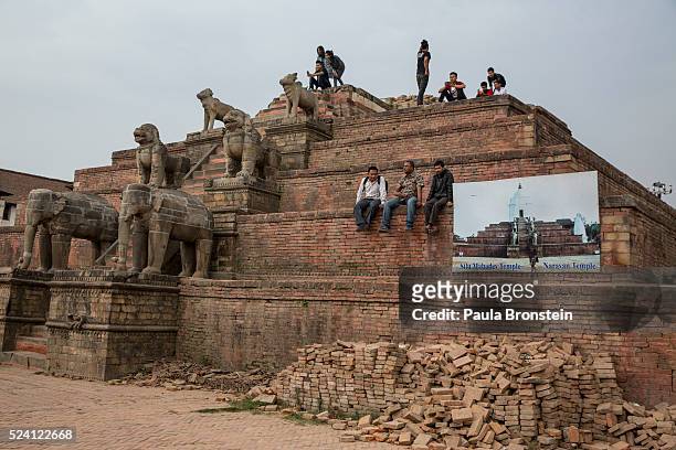 Tourists sit on top of a damaged caravan temple in Durbar Square on April 25, 2016 in Bhaktapur, Nepal. One year after the devastating earthquake,...