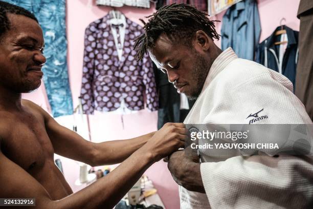 Popole Misenga a refugee judoka from the Democratic Republic of Congo, asks a friend to stitch a sponsor'ss badge on his judogi in Rio de Janeiro,...