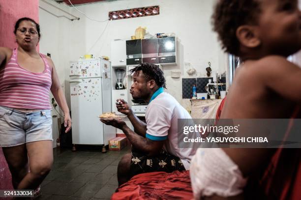 Popole Misenga a refugee judoka from the Democratic Republic of Congo, has lunch with his one-year-old son Heliasin and his partner Fabiana at home...