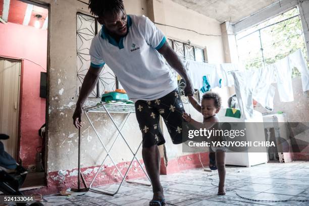 Popole Misenga a refugee judoka from the Democratic Republic of Congo, plays judo with his one-year-old son Heliasin at home in Rio de Janeiro,...