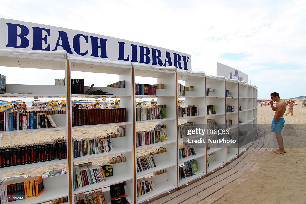 People look for and read books at the first ever free beach library