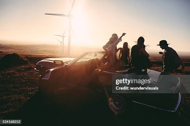 young adult friends enjoing time together with guitar at sunset - wind turbine california stock pictures, royalty-free photos & images