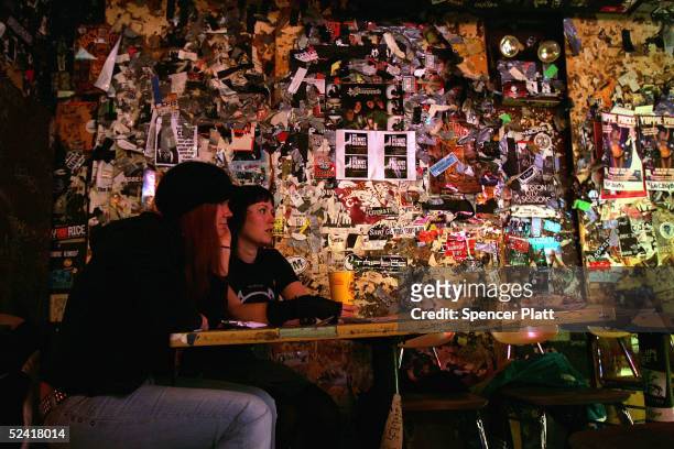 Two women watch a rock band at the club CBGB March 14, 2005 in New York City. CBGB, the legendary punk rock club which helped launch bands such as...