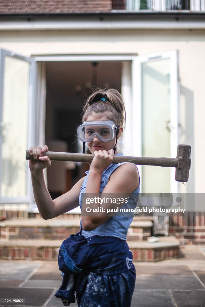 Teenage girl holding sledgehammer