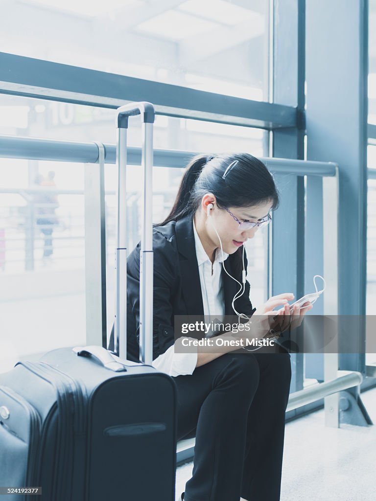 Woman checking smartphone at airport