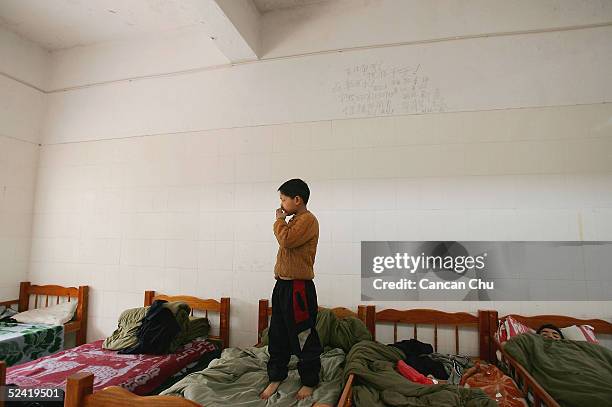 Kid stands on his bed at an assistance center February 23, 2005 in Shenzhen, Guangdong Province, China. The kids, ranging in age from 7 to 16, are...