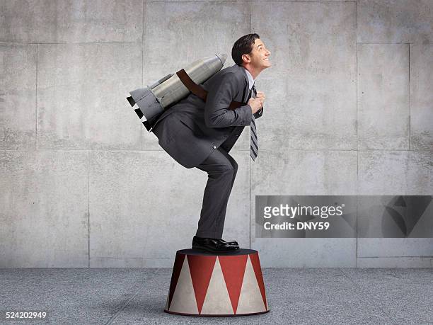 businessman preparing for takeoff on circus pedestal - launch concept stock pictures, royalty-free photos & images