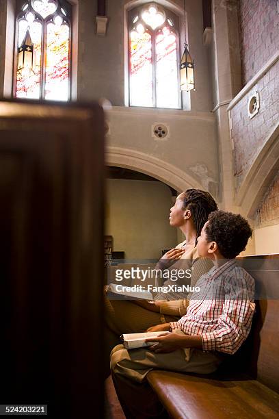 mère et son fils prier de la bible dans l'église - minister clergy photos et images de collection