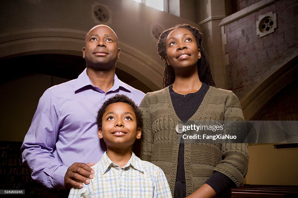 Family Standing and Praying in Church
