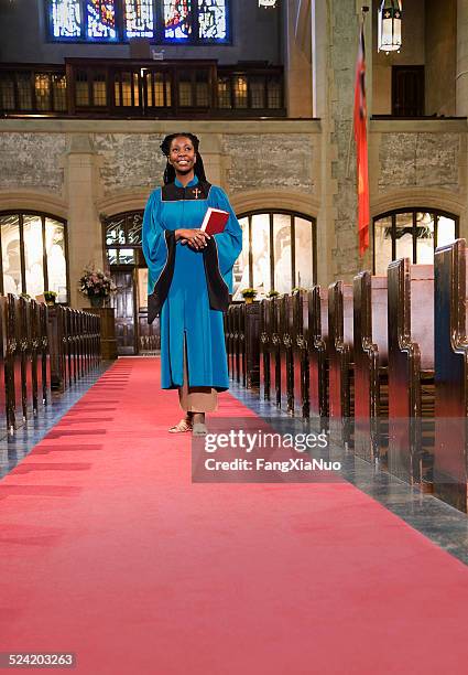 woman clergy member walking down church aisle - clergy stock pictures, royalty-free photos & images