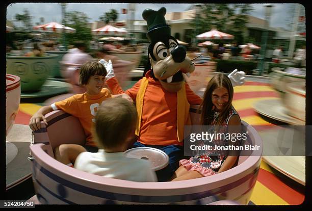 Children with a Goofy character on the Mad Tea Party Ride in the Magic Kingdom at Walt Disney World, Florida, USA, August 1972.