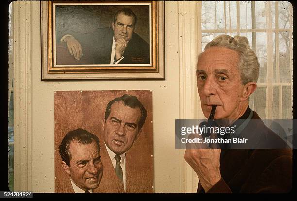 Norman Rockwell smokes a pipe as he stands next his portraits of Richard Nixon in the Norman Rockwell Museum at the "corner house" in Stockbridge,...
