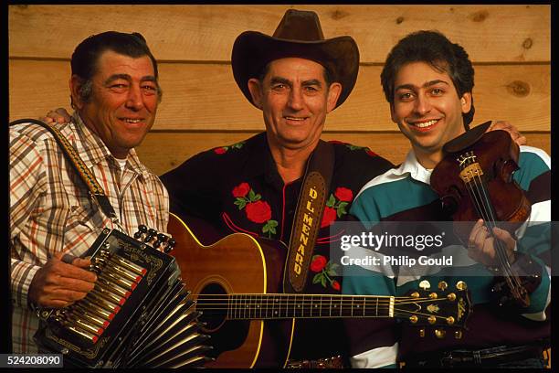 Cajun and country and western singer and guitarist D.L. Menard stands between members of his band. At left, Eddie Lejeune holds his accordion. At...