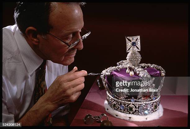 Master Jeweler Henry Phillips has the annual honor of cleaning the real crown jewels. Here he polishes the Imperial State Crown's 2,800 diamonds -...