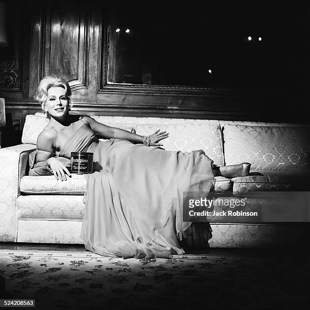 In an advertisment for 'Masterpiece' tobacco, Hungarian-born American socialite and actress Eva Gabor recelines on a sofa, New York, New York, early...
