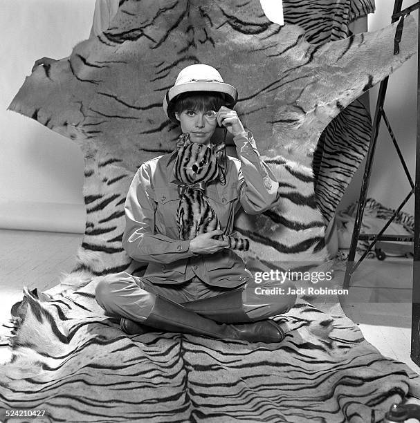 In advertisement for Revlon, American actress Barbara Feldon poses, dressed in jungle garb and seated on tiger fur, New York, New York, 1965.