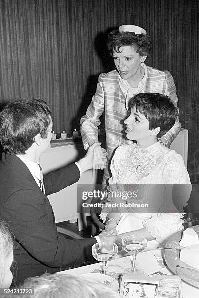 Australian musician Peter Allen sits with his new wife, actress and singer Liza Minnelli, at their wedding and holds hands with Minnelli's mother,...