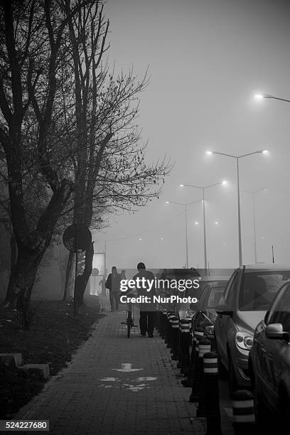 Street lights penetrate a deep fog in Bucharest, where winter is harsh for thousands of minors and young adults living in Bucharest's vast system of...