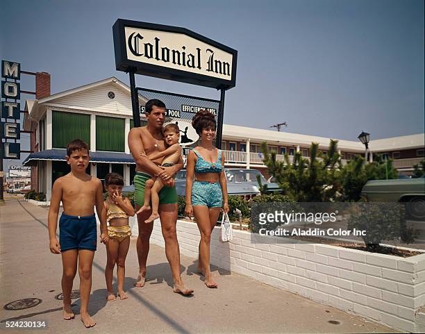 Couple and their three children walk barefoot past the Colonial Inn in Virginia Beach. | Location: Virginia Beach City, Virginia, USA.